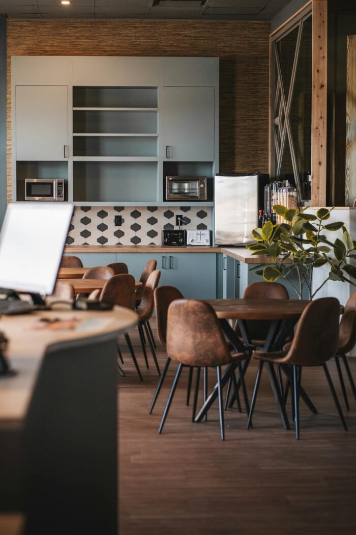 Spacious office kitchenette with seating area, modern furnishings, and natural light